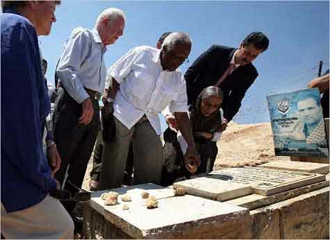 Desmond Tutu, with Jimmy Carter, placing a stone on a grave in Bilin - 27 Aug 2009 